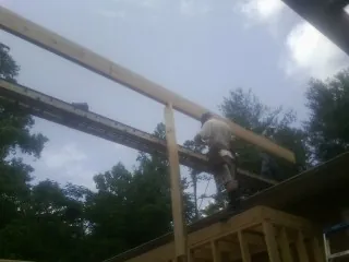 Carpenter setting a ridge beam over a new addition frame — Ice Dam Removal by Roofing Brothers in Ottawa Lake
