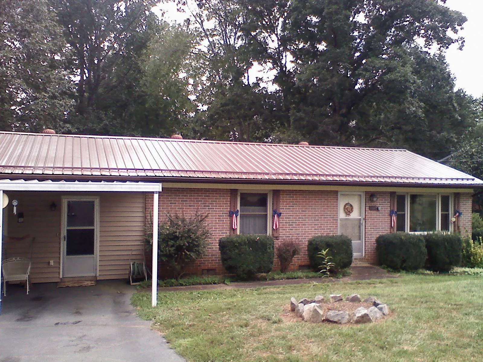 Bronze metal roof and carport on a brick ranch home — Roof Repair work by our crew in Ottawa Lake