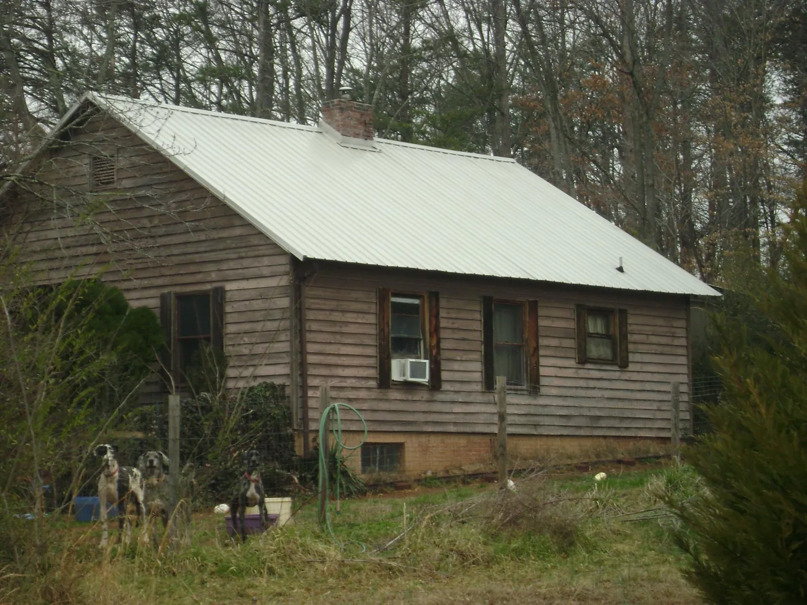 White metal roof on an old wood sided farmhouse, from a Metal Roof Installation job in Ottawa Lake