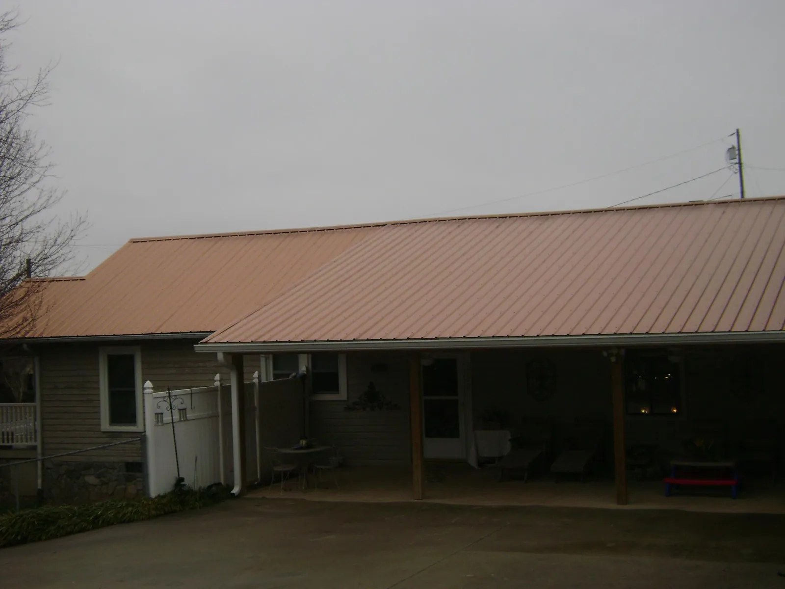 Copper toned metal roof over a wide covered patio in Ottawa Lake